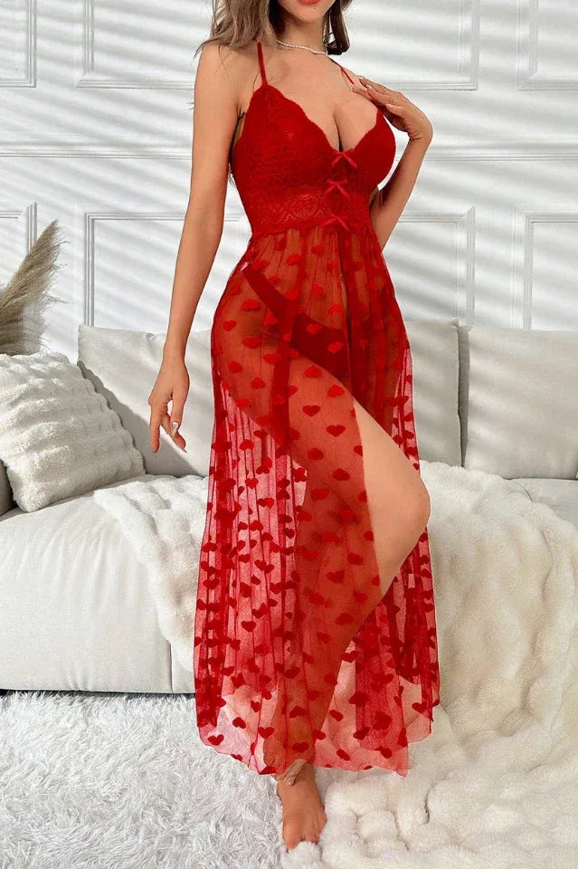 Woman wearing a red sheer mesh chemise with a heart pattern and high slit.