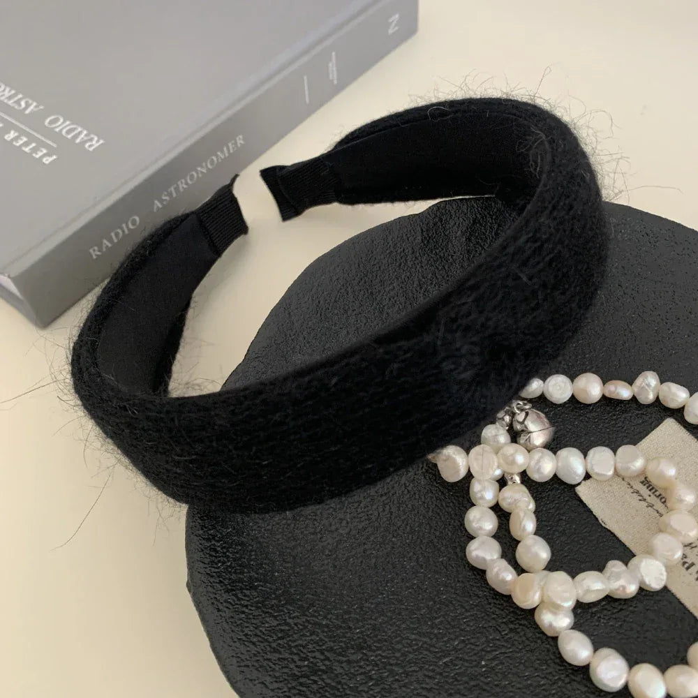 Black knit headband with pearls and a book