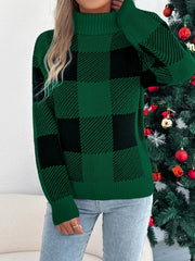 Woman in a green and black buffalo plaid turtleneck sweater with hand on chest