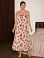 Front view of a woman wearing a cream-colored floral print nightgown with red flowers and ruffle straps, standing in a bedroom.