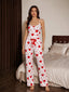 Front view of a woman wearing a white and red heart print pajama set with spaghetti straps and a drawstring waist.