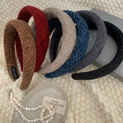 Group of colorful padded headbands displayed with pearls and a book