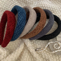 Assortment of textured padded headbands arranged on a white textured background