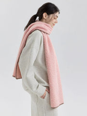 Woman in profile wearing a pink fuzzy knit scarf and grey sweatshirt