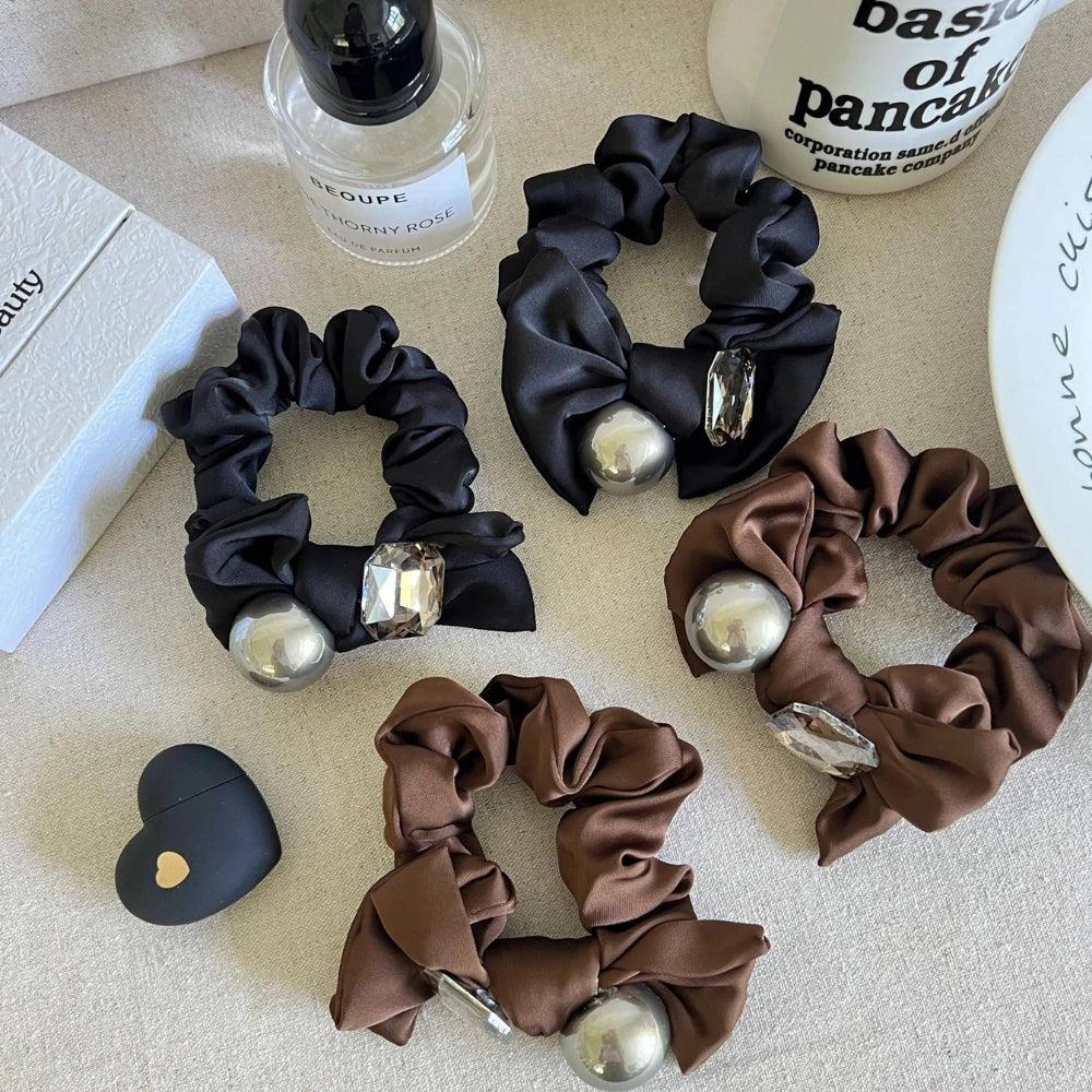 Collection of satin scrunchies in black and brown with metallic sphere and crystal embellishments