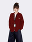 Woman wearing a maroon zip-up knit cardigan with a small embroidered tiger graphic on the left chest, a white t-shirt underneath, and dark wash wide-leg jeans.