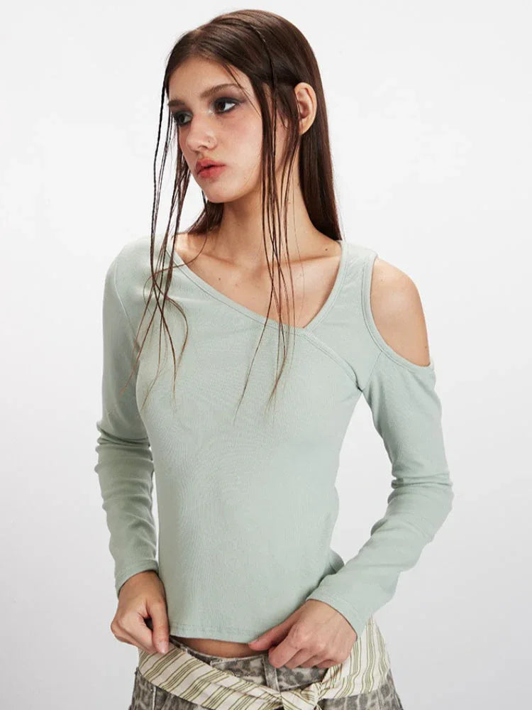 Close-up of a woman's upper body, highlighting the intricate neckline and shoulder detail of the mint green long-sleeved top.