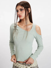 Close-up of a woman's upper body, highlighting the intricate neckline and shoulder detail of the mint green long-sleeved top.