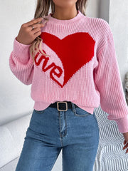 Woman wearing a pink knit sweater with a red heart graphic and the word "love" on the front, with a belt.