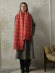 woman wearing a grey coat and a red plaid scarf