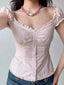 Close-up of a pink striped and floral print top with ruffle trim and puff sleeves.