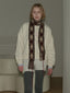Model wearing a cream sweatshirt, argyle scarf, and grey leggings