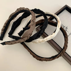 Collection of braided headbands in brown, black, and cream