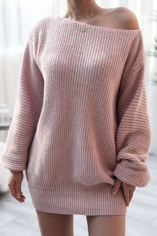 Woman wearing a pink off-the-shoulder ribbed knit tunic sweater.