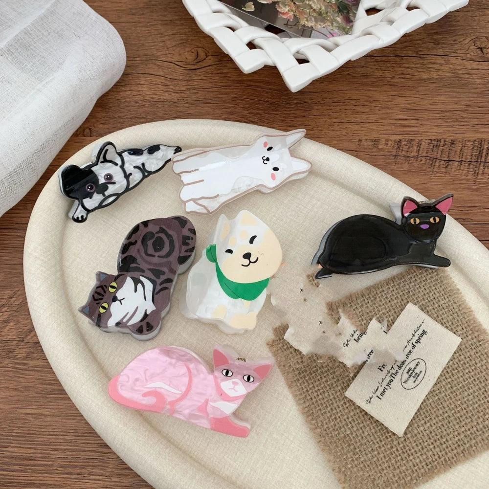 Several cat-shaped hair clips are laid out on a white tray.