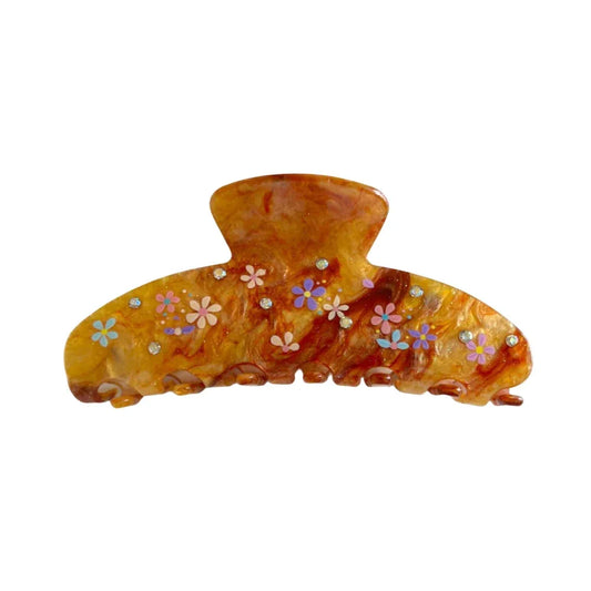 A single brown marbled hair claw clip with small colorful floral patterns and clear gemstone accents against a white background.
