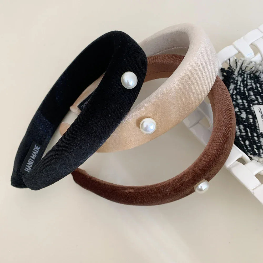 three padded headbands in black, beige, and brown, arranged on a surface
