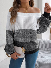 Woman holding a white handbag and wearing a color block off-the-shoulder knit sweater.