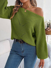 Close-up of a woman wearing a green off-the-shoulder knit sweater with a textured pattern and lantern sleeves, showing the neckline and texture.