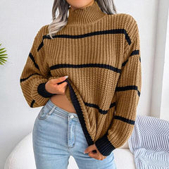 Woman wearing a brown and black striped knit sweater with a high neckline and long sleeves, paired with light blue jeans.