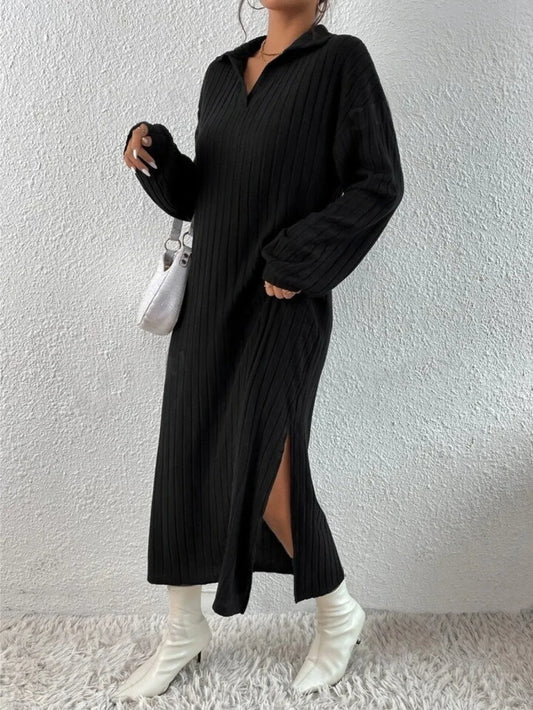 Woman wearing a black long-sleeved ribbed knit dress with a high slit, white boots, and a white handbag.