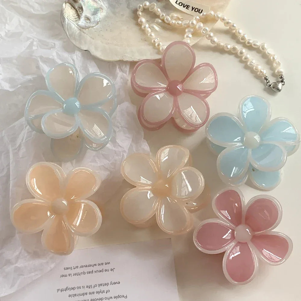group of six flower claw clips in various pastel colors including peach, pink, and blue