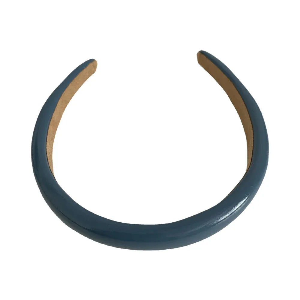 A single blue padded headband on a white background