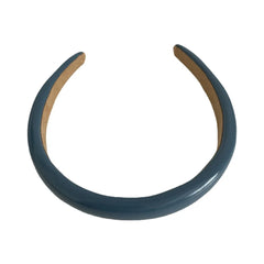 A single blue padded headband on a white background