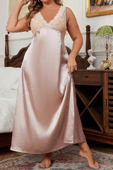 Woman wearing a long satin nightgown with lace trim, standing and adjusting the hem of the gown.