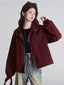 Woman wearing a maroon bomber jacket, black crop top, and light wash jeans