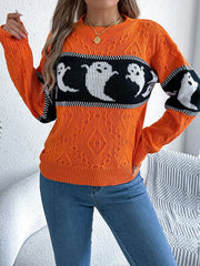 Front view of a woman wearing an orange Halloween sweater with a ghost print, standing with her hand on her hip.