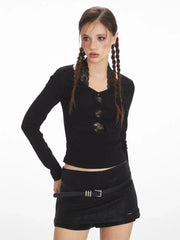 Woman with braids wearing a black long-sleeve top and black mini skirt