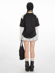 Back view of the outfit, showing the graphic print on the back of the shirt and the ruffled texture of the shorts.