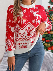 Woman wearing a red and white Christmas sweater with a reindeer pattern, standing in front of a Christmas tree.
