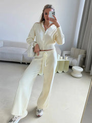 Woman posing with a cream handbag in a cream knit loungewear set