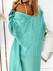 Woman from behind wearing an aqua knit cardigan, with the cardigan draped off one shoulder.