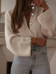 Side view of the model in the cream knit cardigan and denim, highlighting the silhouette and sleeve volume.