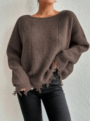 Woman wearing a brown oversized distressed knit sweater with black pants
