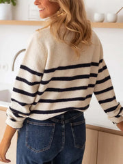 Back view of a woman wearing a striped knit sweater and blue jeans