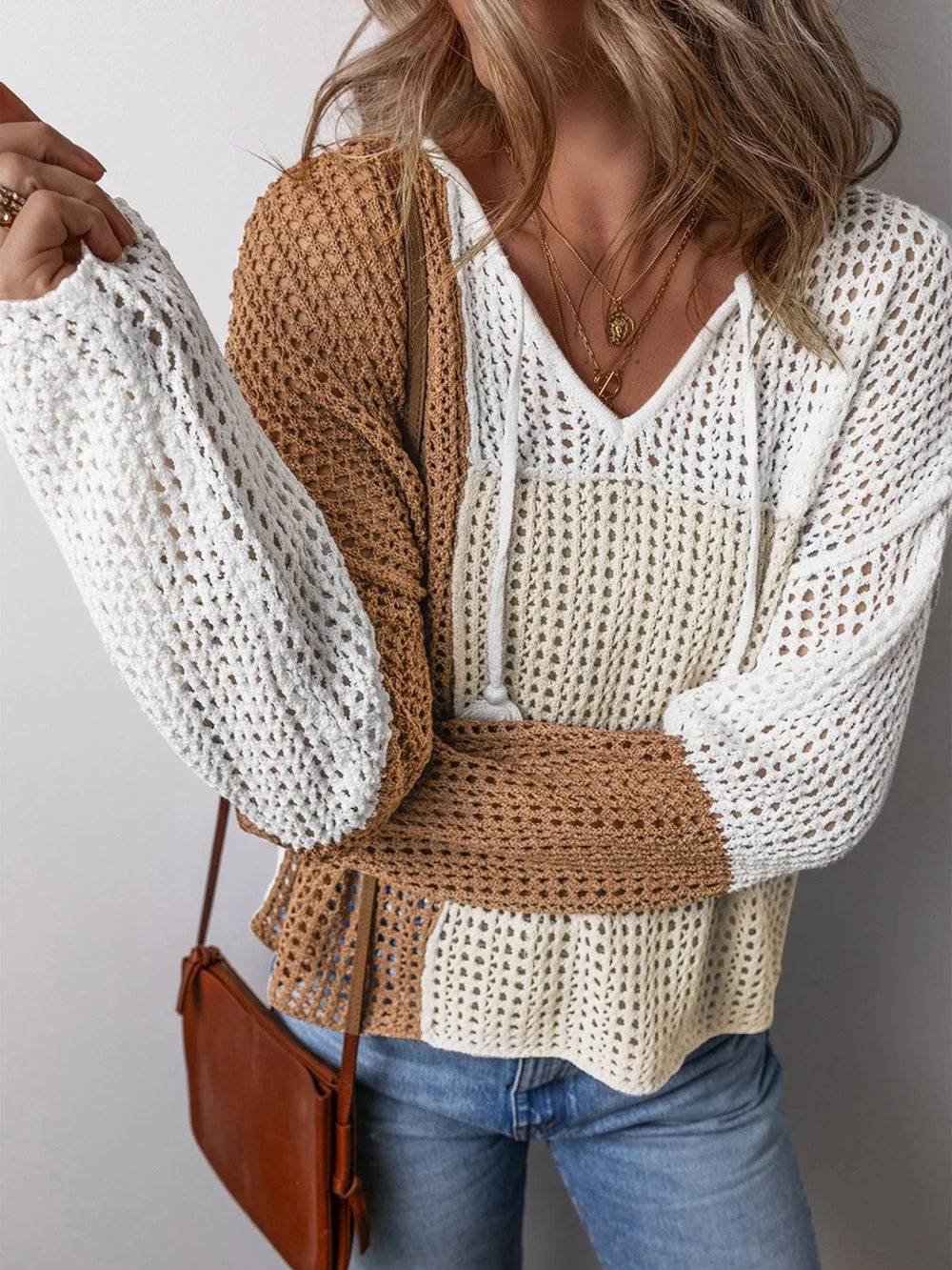 Close-up of a woman wearing a color block knit sweater, showing the texture and details.