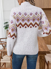 Back view of a woman wearing a white fuzzy knit sweater with a geometric Fair Isle pattern and dark wash jeans.