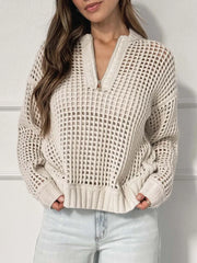 Woman wearing a cream open knit quarter-zip sweater with light wash jeans.