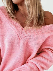 Close-up of the V-neckline and knit texture of a pink oversized sweater.