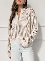 Front view of a woman wearing a cream open knit quarter-zip sweater with light wash jeans.