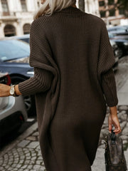 Back view of a woman wearing a long brown knit cardigan.