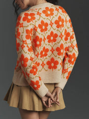 Back view of a woman wearing a cream knit cardigan with an orange floral print.