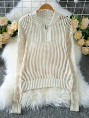 Cream open knit quarter-zip sweater displayed on a hanger with decorative roses.