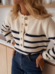 Woman wearing a striped knit sweater and blue jeans, hands on hips