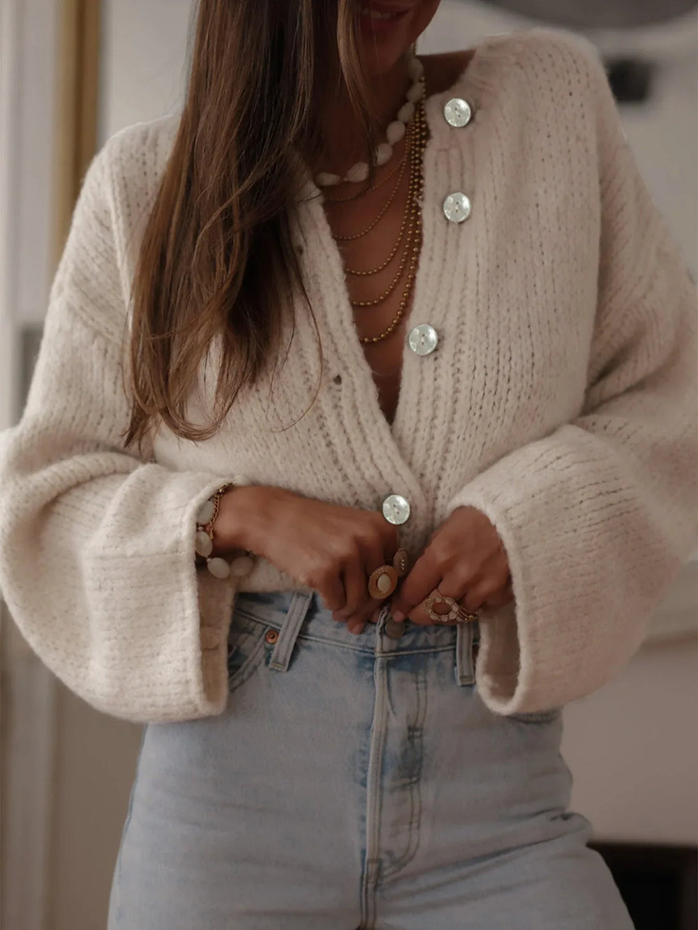 Close-up of the front of the cream chunky knit cardigan, showing the button details and textured knit.