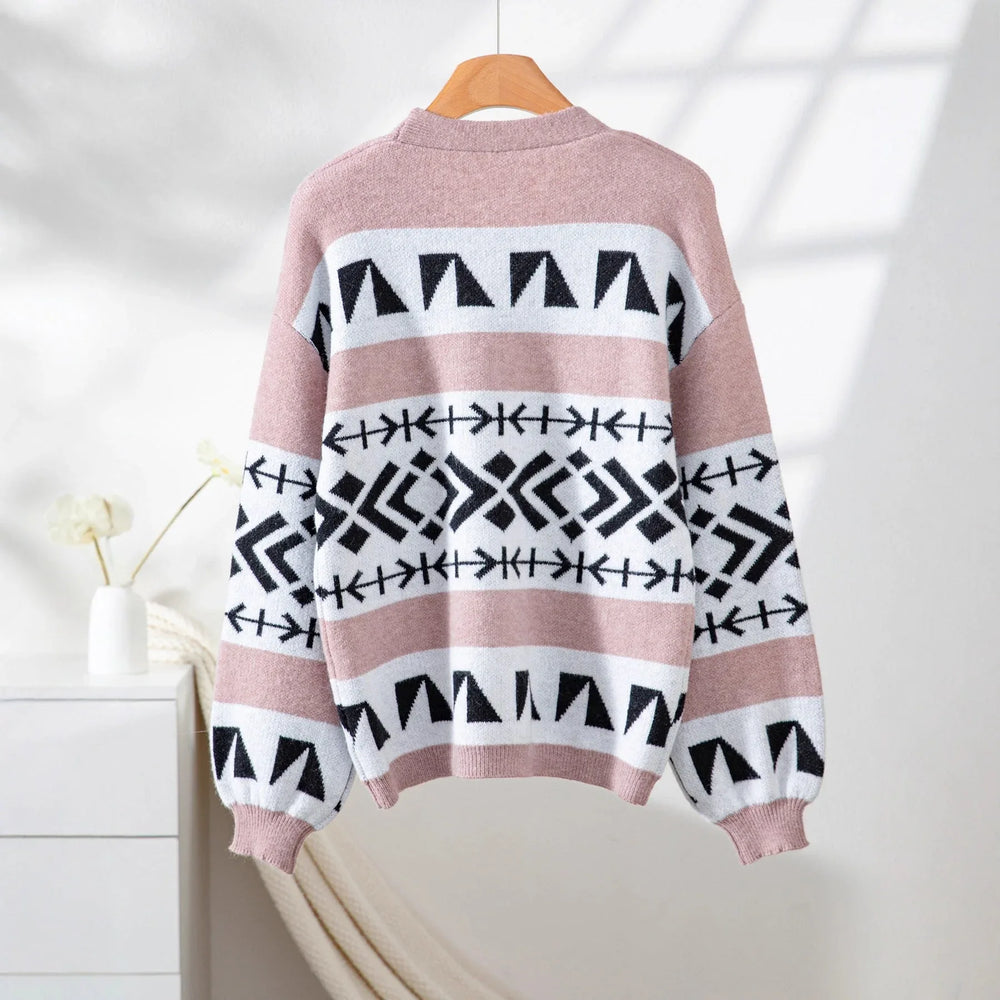 back view of a pink and black geometric print knit cardigan hanging on a wooden hanger